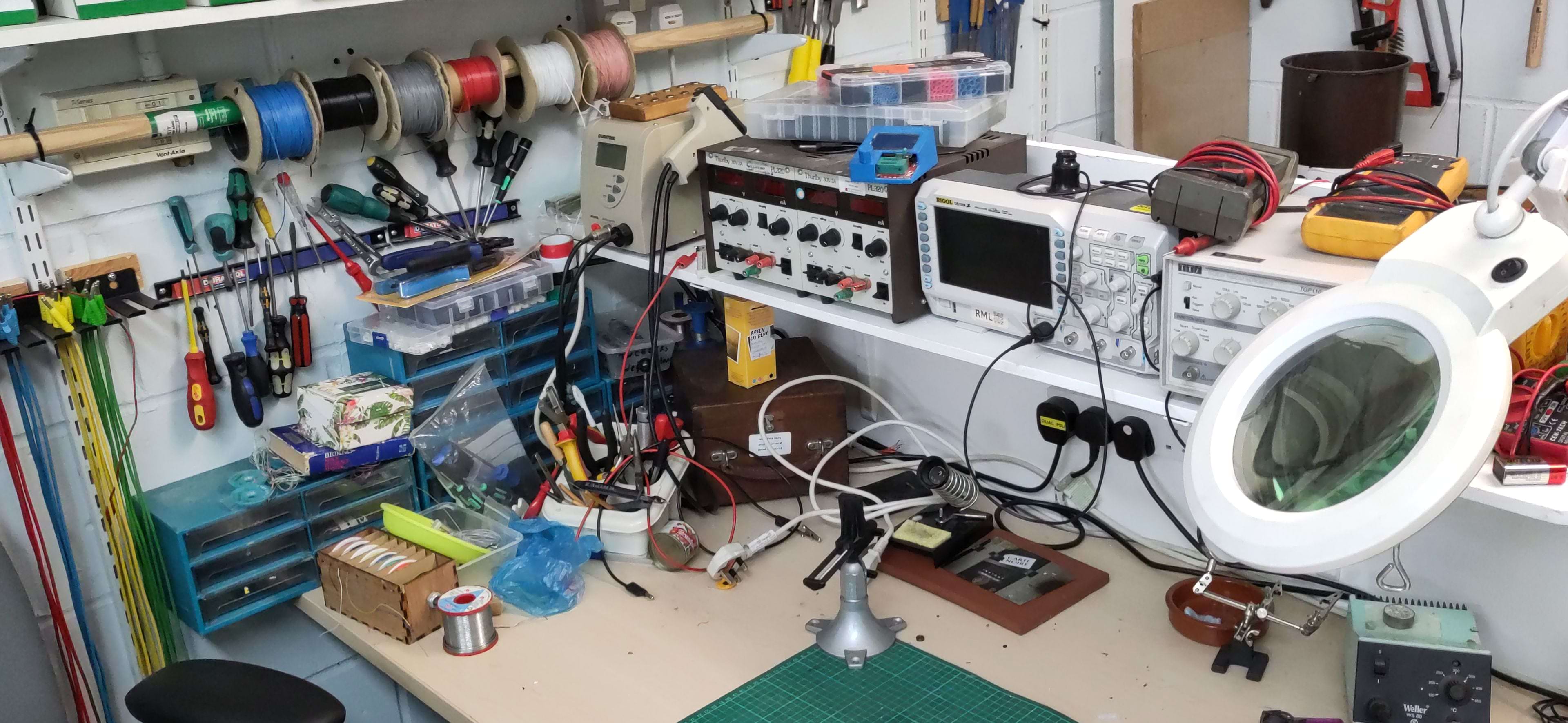 soldering iron, oscilloscope, and several electronic comonents on a table. 