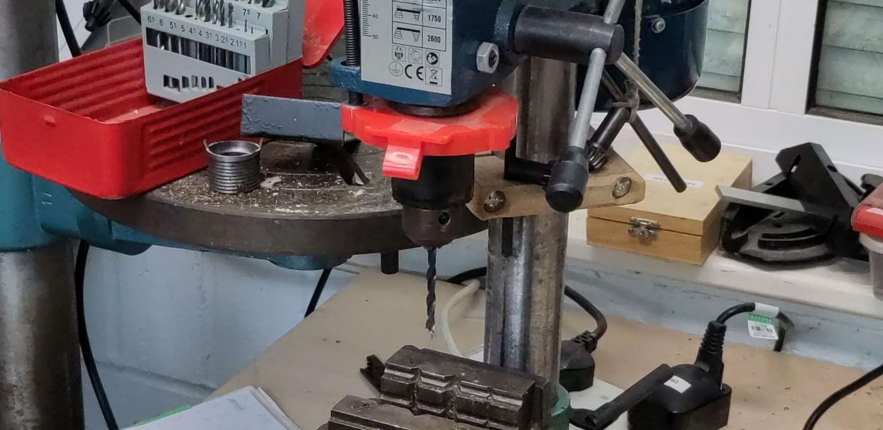 A narrow view of a desktop pillar drill.